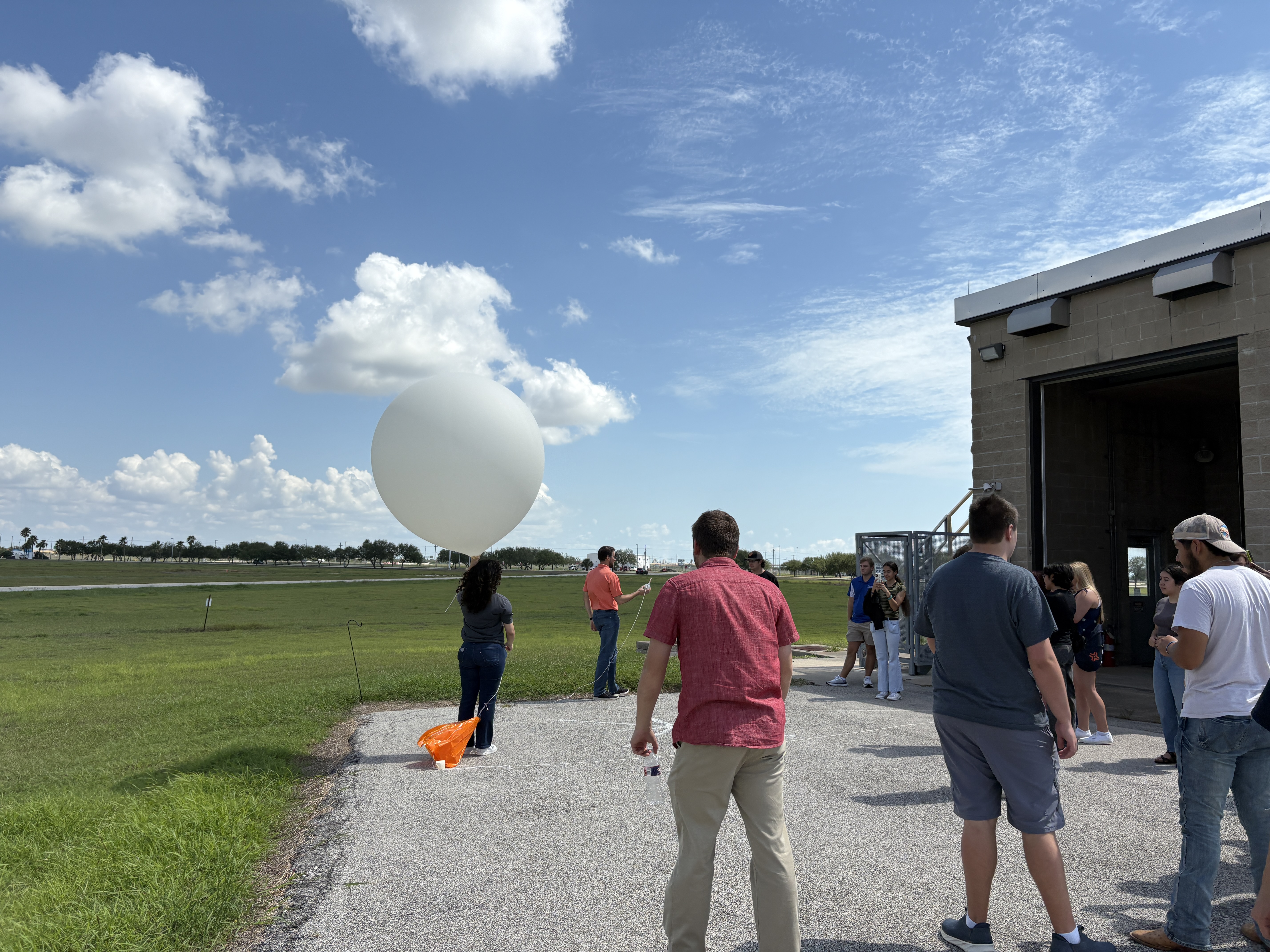 Undergraduate students launching a weather balloon at the NWS