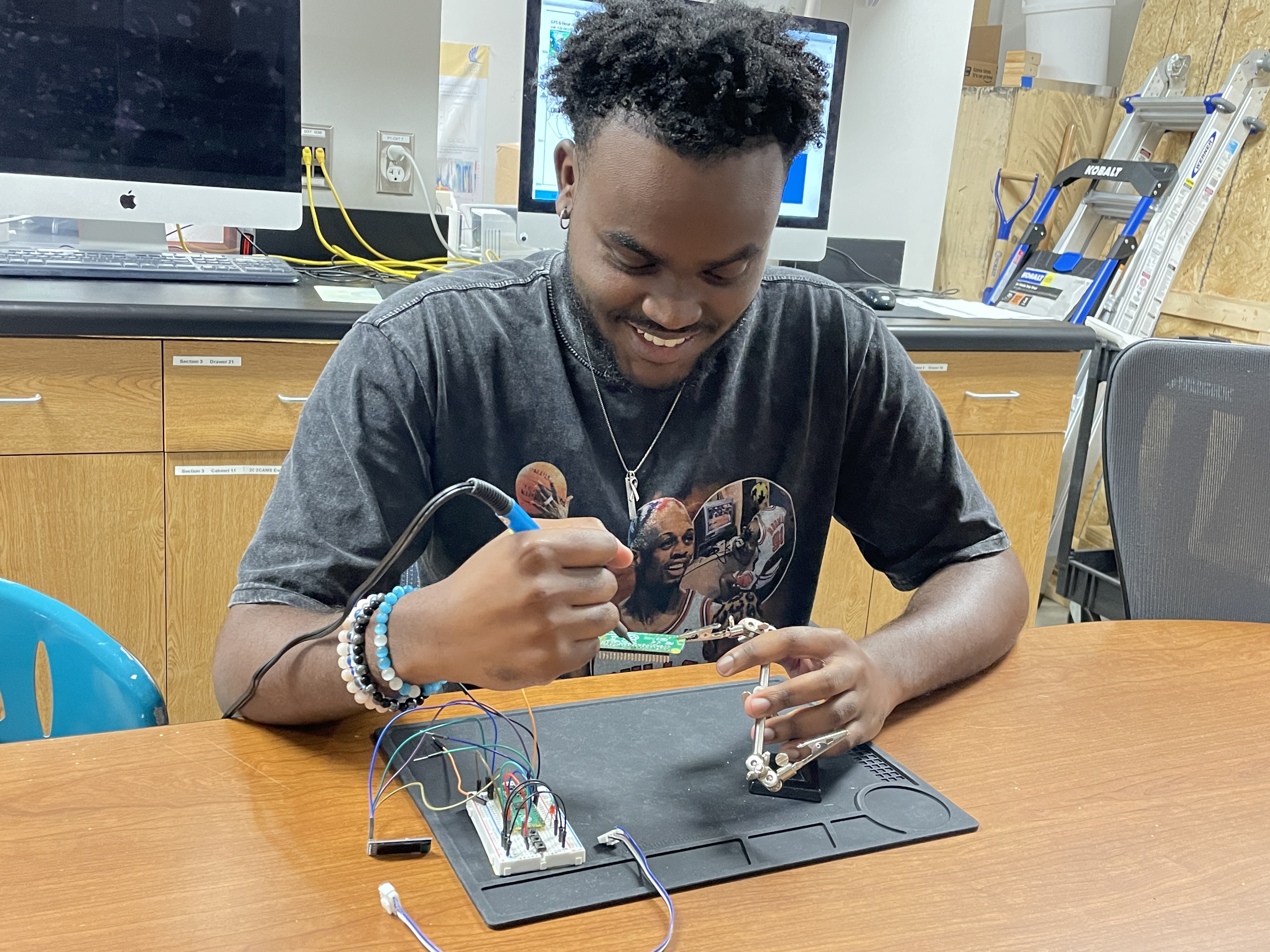 M.S student, Quincy Walker, soldering connections to a Rasberry Pico